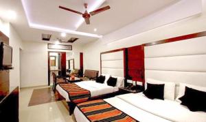 a room with four beds and a ceiling fan at FabHotel Station 3 in New Delhi