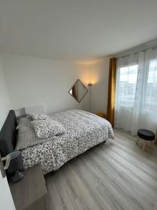 a white bedroom with a bed and a window at Little Livia in Créteil