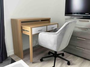 a desk with a chair next to a television at Little Livia in Créteil