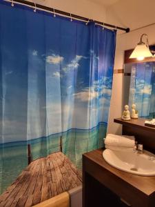 a bathroom with a shower curtain with a view of the ocean at Disney Paris Appartement in Montévrain