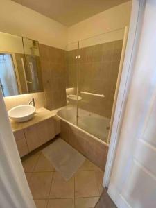 een badkamer met een douche, een wastafel en een bad bij Cosy flat in Boulogne in Boulogne-Billancourt