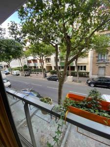 een uitzicht vanuit een raam van een straat met een boom bij Cosy flat in Boulogne in Boulogne-Billancourt