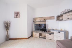 a living room with a large wooden entertainment center at The Balcony - By Wehost in Santa Cruz