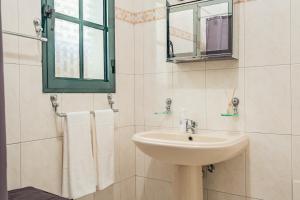 a white bathroom with a sink and a mirror at The Balcony - By Wehost in Santa Cruz +32 photos