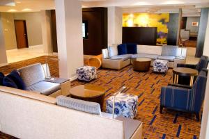 a lobby with couches and chairs and a television at Courtyard Waterbury Downtown in Waterbury