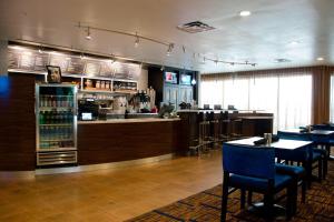 a restaurant with a bar and some tables and chairs at Courtyard Waterbury Downtown in Waterbury