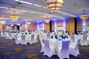 a banquet hall with white tables and chairs and chandeliers at Courtyard Waterbury Downtown in Waterbury