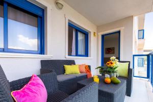 un patio con sillas de mimbre negro y almohadas coloridas en Alicante Hills Premium, en Alicante
