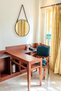 een houten bureau met een stoel en een spiegel bij HOTEL WHITE RABBIT in Pushkar