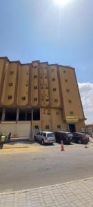 a large building with cars parked in front of it at العاصفة in Khamis Mushayt