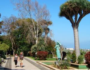 two people walking down a sidewalk next to a statue at La Pernocta in Arucas