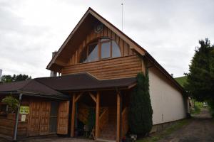 a house with a gambrel roof and a garage at Penzión na gazdovskom dvore in Dolný Kubín