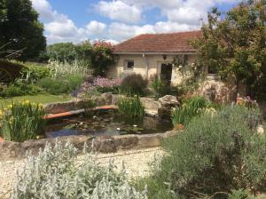 un giardino con laghetto di fronte a una casa di La Petite Maison a Crézières