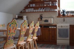 uma cozinha com 4 cadeiras, uma mesa e um fogão em Penzión na gazdovskom dvore em Dolný Kubín
