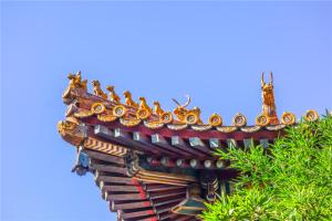 un techo ornamentado de un edificio con un árbol en The East Hotel-Very close to the Drum Tower,The Lama Temple,Houhai Bar Street,and the Forbidden City,There are many old Beijing hutongs around the hotel Experience the culture of old Beijing hutongs,Near Exit A of Shichahai on Metro Line 8, en Beijing