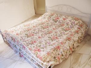 Una cama blanca con una manta floral. en Tablinum, en Bellagio