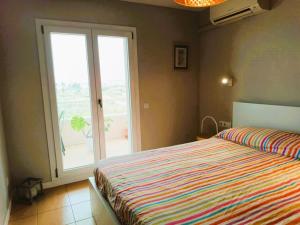 a bedroom with a bed and a large window at Villa Service - Coral III in El Vendrell