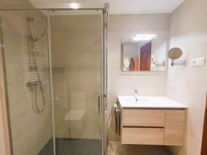 a bathroom with a glass shower and a sink at Villa Service - Coral III in El Vendrell
