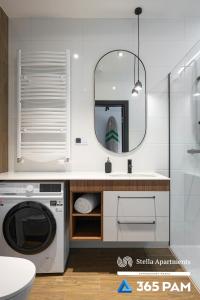 a bathroom with a washing machine and a mirror at Hawaje apartament przy plaży - 365PAM in Sianozety