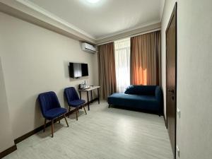 a hotel room with a blue couch and chairs at Lumarc Hotel in Bishkek