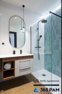 a bathroom with a sink and a shower with a mirror at Hawaje apartament przy plaży - 365PAM in Sianozety