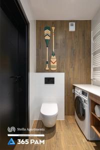 a bathroom with a toilet and a washing machine at Hawaje apartament przy plaży - 365PAM in Sianozety