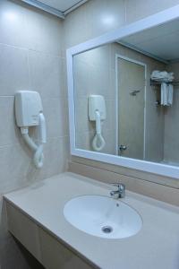 a bathroom with a sink and a mirror at Adi Hotel in Eilat