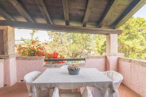 een witte tafel met witte stoelen op een patio bij Apartments Rotondo Residence From The Beach - Happy Rentals in Porto Rotondo