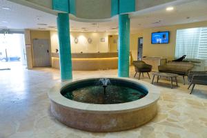 a lobby with a fountain in the middle of a building at Adi Hotel in Eilat