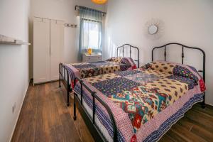 2 łóżka pojedyncze w pokoju z drewnianą podłogą w obiekcie Villa Nisa apartment w mieście Fontane Bianche