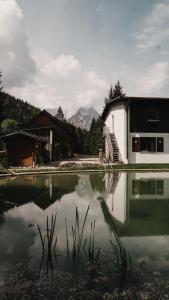 uma casa e um lago com um edifício e montanhas em Toni Hütte am Riesserkopf em Garmisch-Partenkirchen