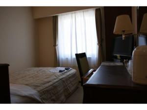 a hotel room with a bed and a desk and a television at Ichihara Marine Hotel - Vacation STAY 01365v in Ichihara