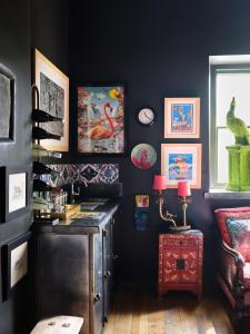 a room with a black wall with paintings and a table at Alpine Apartments Snowdonia in Betws-y-coed