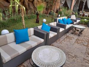Imperial Holiday Hôtel & spa في مراكش: صف من الأرائك وطاولة مع الوسائد الزرقاء