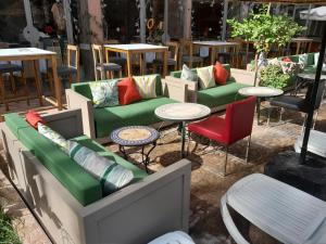 Imperial Holiday Hôtel & spa في مراكش: مجموعة من الأرائك الخضراء والطاولات والكراسي