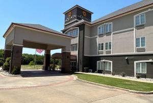 ein Hotel mit amerikanischer Flagge davor in der Unterkunft La Quinta by Wyndham Sulphur Springs in Sulphur Springs