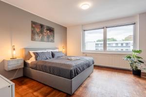een slaapkamer met een bed en een groot raam bij Luxus Loft I Wi-Fi I Gasgrill I Feldmarksee I 3 Schlafzimmer in Sassenberg