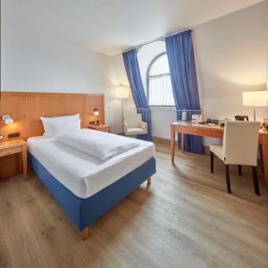 Habitación de hotel con cama, escritorio y escritorio. en Best Western Hotel Trier City en Tréveris
