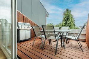 een patio met een tafel en stoelen op een balkon bij Luxus Loft I Wi-Fi I Gasgrill I Feldmarksee I 3 Schlafzimmer in Sassenberg