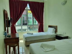 um quarto de hotel com duas camas e uma janela em OYO 90440 Good View Inn em Sri Aman
