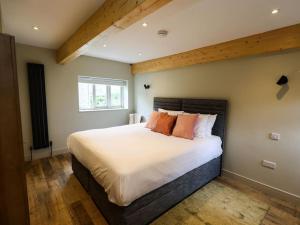 a bedroom with a large bed with orange pillows at Spacious 1-bed apartment with super king or twin in central Charlbury, Cotswolds in Charlbury