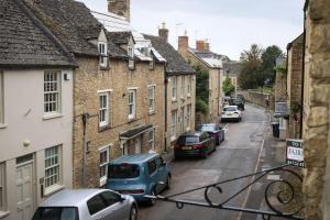 a city street with cars parked on the street at Spacious 1-bed apartment with super king or twin in central Charlbury, Cotswolds in Charlbury