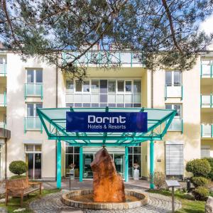 a sign in front of a dmg hotel and resorts building at Dorint Seehotel Binz-Therme in Binz