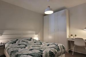 una camera con letto, scrivania e sedia di Appartement Terrasse 17 m² Centre historique a Lons-le-Saunier