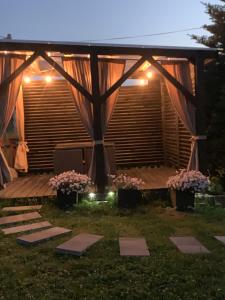 drewniana pergola z różowymi kwiatami i światłami w obiekcie Gościniec u Bobaków w Zębie