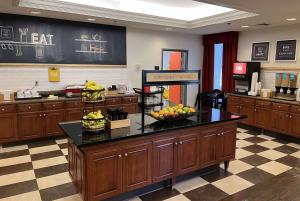 a cafeteria with a counter with fruit on it at Wingate by Wyndham St Louis Airport in Saint Ann