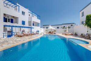 a swimming pool with blue water in front of a building at Armenaki in Azolimnos Syros