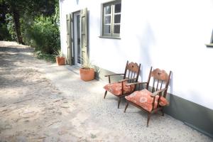 dos sillas y una mesa frente a un edificio en Vumba Agroturismo, en Arganil