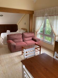 uma sala de estar com um sofá e uma cama em Apartamentos Playa de Nemiña em Nemiña