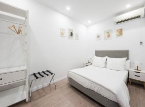 a white bedroom with a bed and a desk at No Limit Barcelona Central in Barcelona